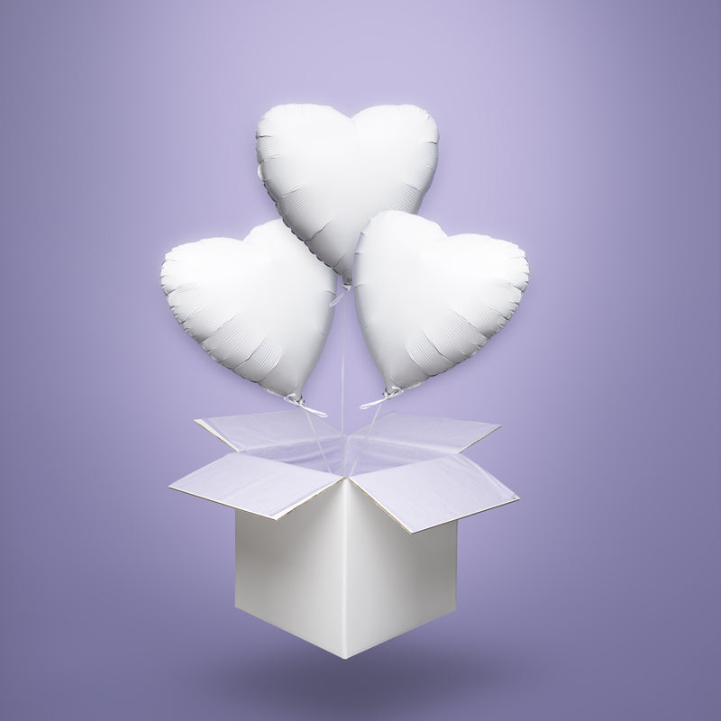 Trzy białe balony foliowe w kształcie serc, wypełnione helem i wyskakujące z białego kartonu – elegancka dekoracja ślubna, rocznicowa lub na chrzest.
