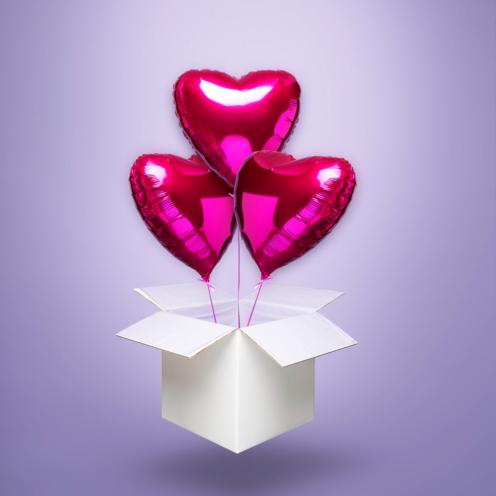 Trzy połyskujące różowe balony foliowe w kształcie serc, wypełnione helem i wyskakujące z białego kartonu – idealna romantyczna niespodzianka na Walentynki, rocznicę lub urodziny ukochanej osoby.