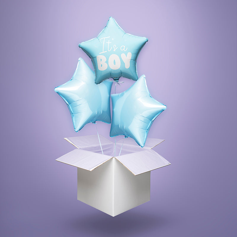 Trzy niebieskie balony foliowe w kształcie gwiazdek z napisem „It’s a Boy”, wypełnione helem i wyskakujące z białego kartonu – idealna dekoracja baby shower chłopca lub prezent na narodziny.
